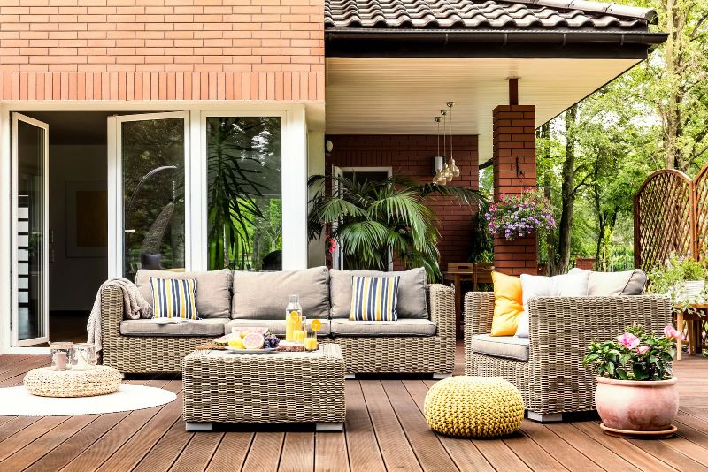 patio right in front of the house with outdoor furniture and potted plants