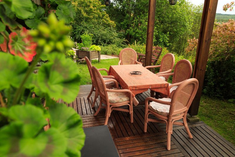 timber deck with dining table and chairs and plants